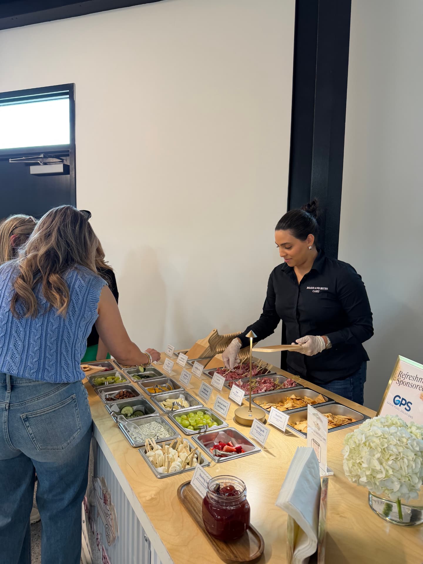 An attendant serving guests building their own boards at the cart