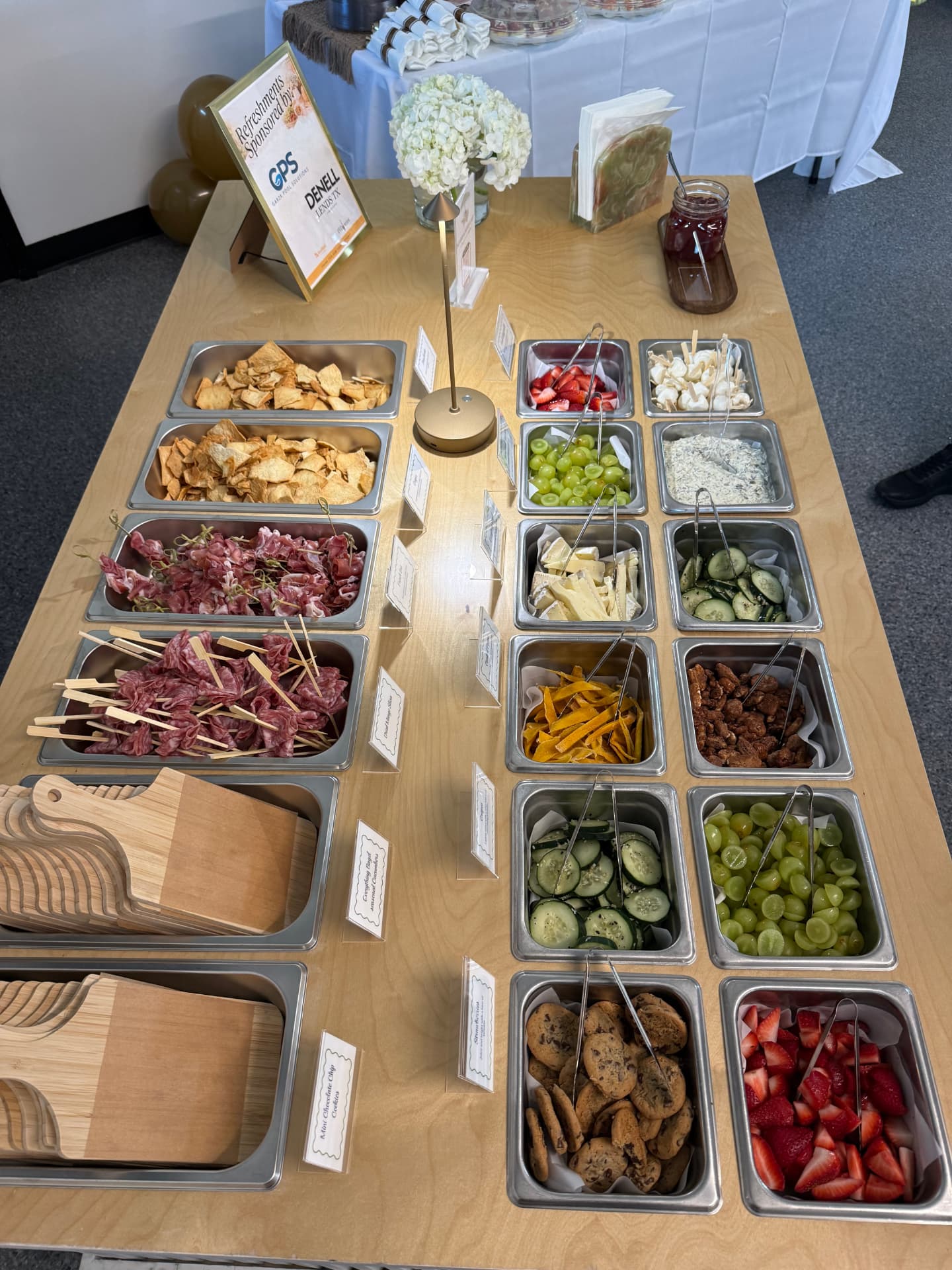 Overhead view of labeled trays of salami, cheeses, fruit and crackers